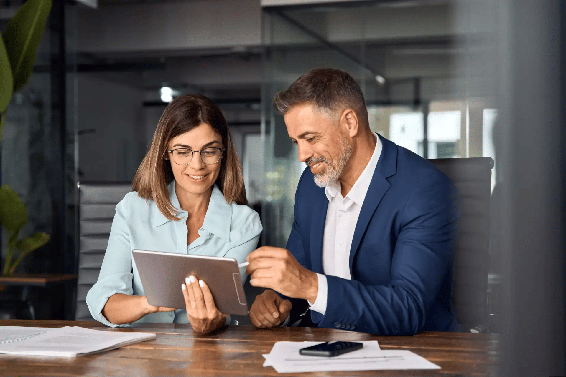man and woman looking at tablet together