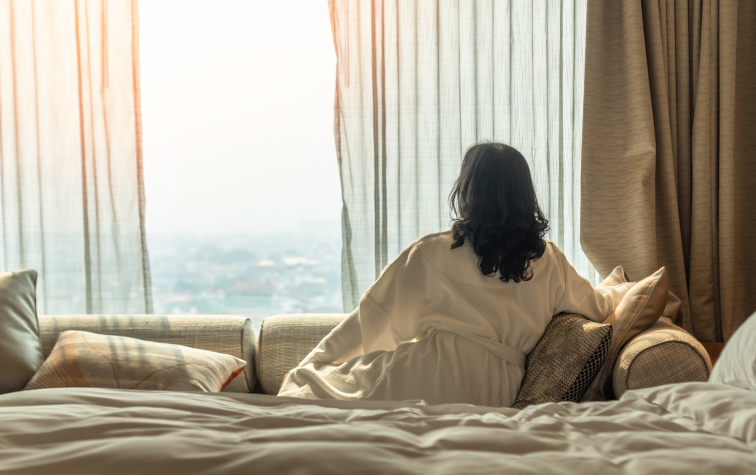 Woman looking out hotel window